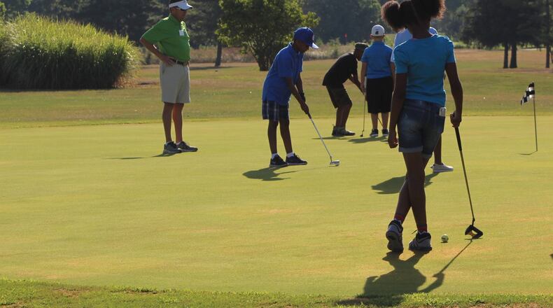 Children practice golf at the city of Dayton’s Madden Golf course. CORNELIUS FROLIK / STAFF