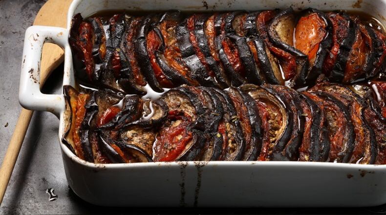 Eggplants are sliced at regular intervals (but not all the way through), then tomato clices are sandwiched in. The finished dish can be served hot, cold or at room temperature, making it flexible for summer entertaining. (E. Jason Wambsgans/Chicago Tribune/TNS)