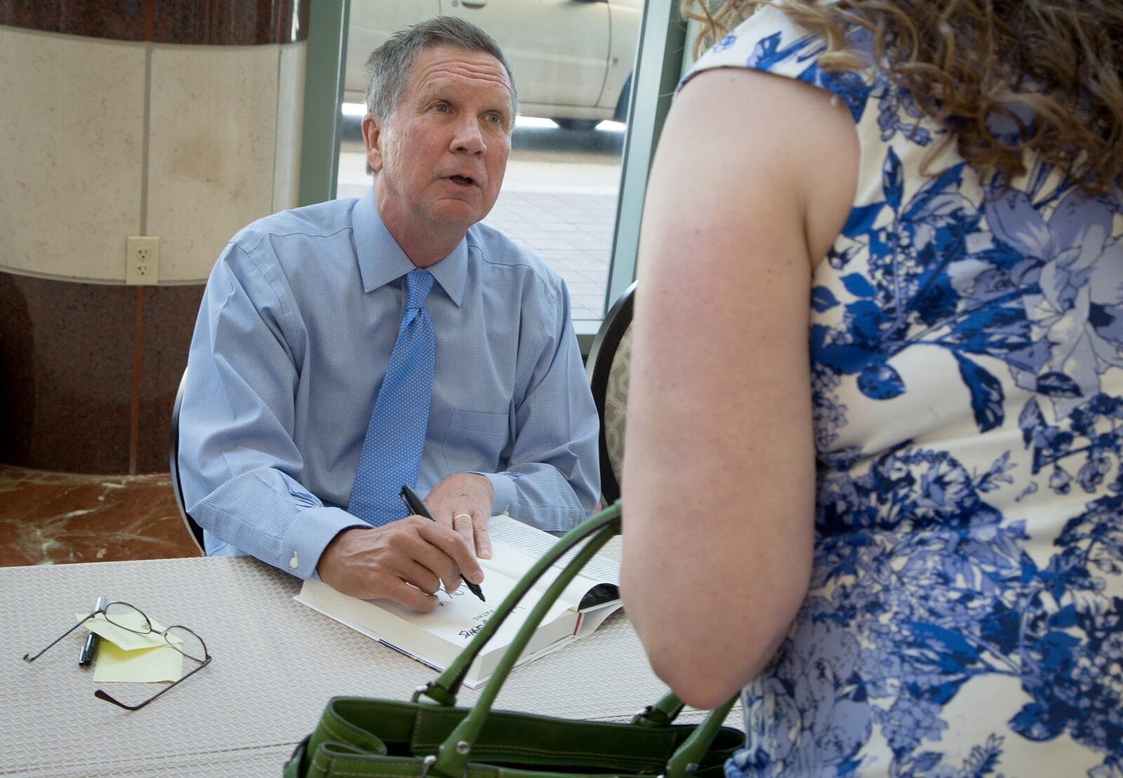 Ohio Gov. John Kasich signs his new book, “Two Paths: America Divided or United” after speaking at Forum Club of the Palm Beaches in West Palm Beach, Florida on Friday, May 26, 2017. (Allen Eyestone / The Palm Beach Post)