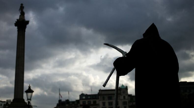 FILE PHOTO: An attorney who dressed as the Grim Reaper to protest the reopening of Florida beaches is plunking down crosses to mark coronavirus deaths.