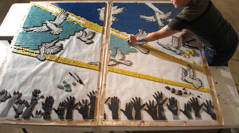 Jes McMillan, founder of The Mosaic Institute of Greater Dayton, along with her staff, designed a mosaic mural, "9 Doves," to commemorate the nine people killed in the Oregon District shooting. LISA POWELL / STAFF