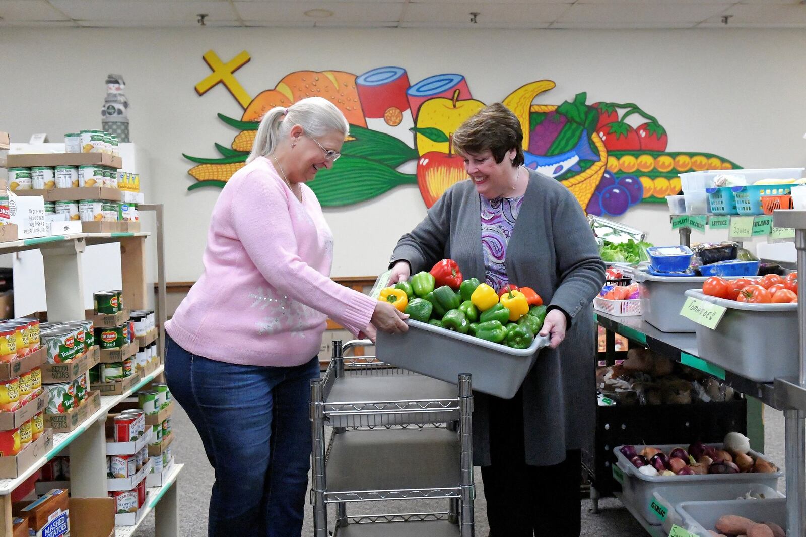 Donna Wilkerson (left) and Sharon Buse prepare offerings for clients at the First Place Food Pantry in Troy. Contributed photo.