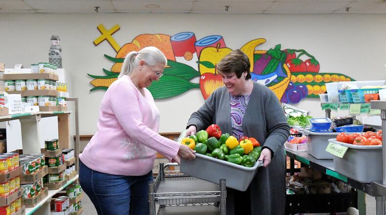 Donna Wilkerson (left) and Sharon Buse prepare offerings for clients at the First Place Food Pantry in Troy. Contributed photo.