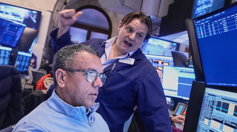 Traders Robert Finnerty Jr., foreground, and Michael Milano work on the floor of the New York Stock Exchange, Monday, Jan. 26, 2026. (AP Photo/Richard Drew)