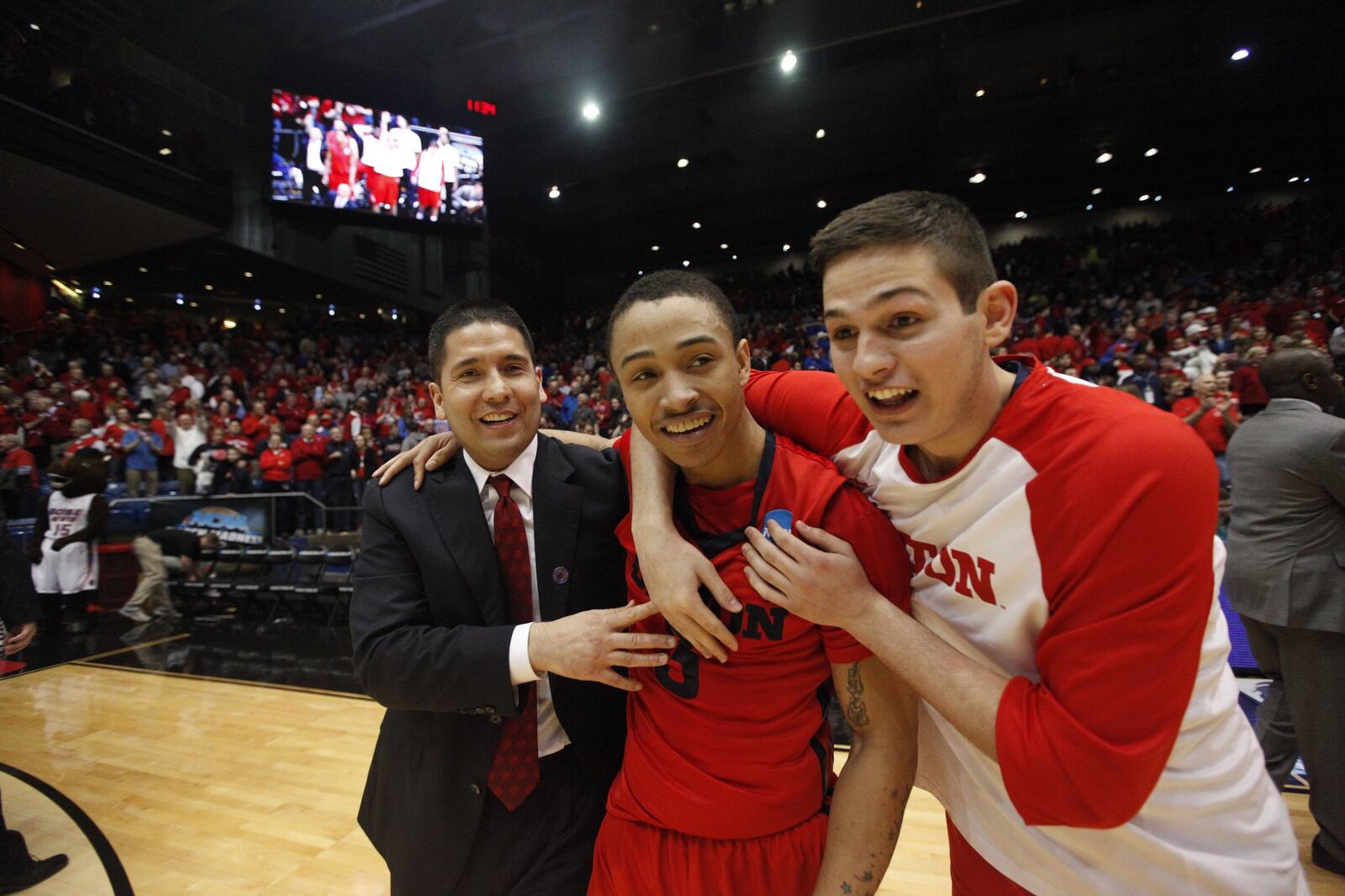 Dayton assistant coach Tom Ostrom, Kyle Davis and Nick Haldes celebrate after a victory against Boise State in the First Four on Wednesday, March 18, 2015, at UD Arena. David Jablonski/Staff