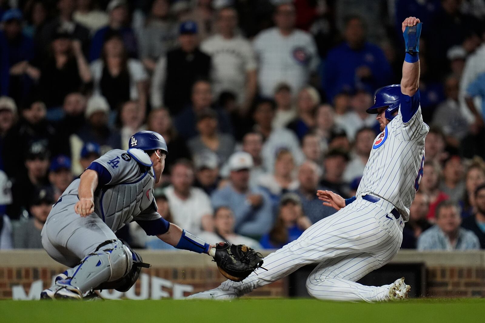 Chicago Cubs left fielder Ian Happ (8), right, is tagged out at home base by Los Angeles Dodgers catcher Will Smith (16) during the sixth inning of a baseball game Tuesday, April 22, 2025, in Chicago. (AP Photo/Erin Hooley)