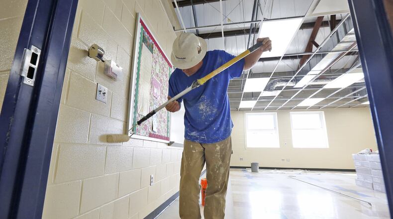 Brian Fenton paints a classroom before new ceiling tile is installed in Brookville High School after the building was damaged by the Memorial Day tornado. The district is getting ready for an expected school opening date of August 15. TY GREENLEES / STAFF