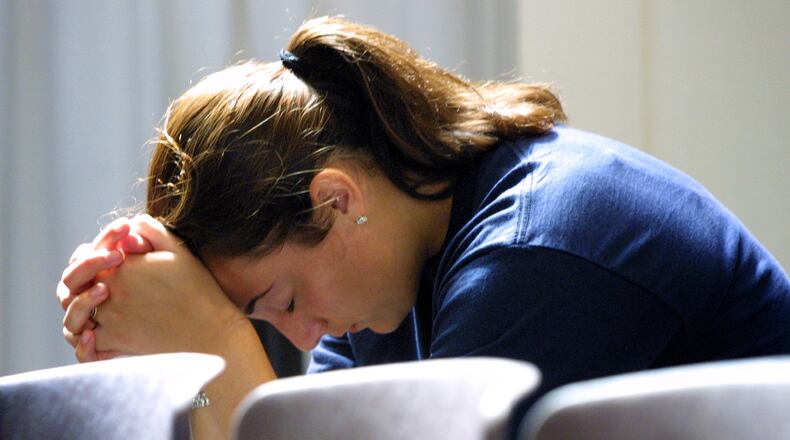 Angie DelRosso, a University of Dayton junior from Cincinnati, bows her head in prayer following the service at the UD Chapel in response to the day's news of terrorist attacks on the World Trade Center and the Pentagon. DelRosso said, "I don't even know what to think. I don't know what to say. I just came here for a type of comfort." DAYTON DAILY NEWS ARCHIVE