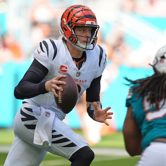 Cincinnati Bengals quarterback Joe Burrow, left, scrambles during the first half of an NFL football game against the Miami Dolphins, Sunday, Dec. 21, 2025, in Miami Gardens, Fla. (AP Photo/Rebecca Blackwell)