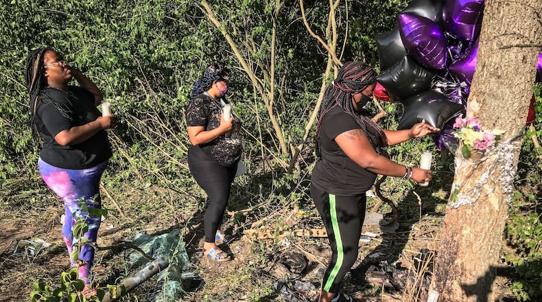 Mourners Talisha Hawkins, Natasha Sutton and Kasaundra Moreland, light a candle at the crash site where their friend Leah Smith, 35, of Dayton, was killed Wednesday night, July 15, 2020. Smith's 3-year-old son survived the crash after her car was struck by another car at the intersection of Olive and Little Richmond roads in Trotwood. Two teens in the other vehicle also did not survive. JIM NOELKER/STAFF FILE