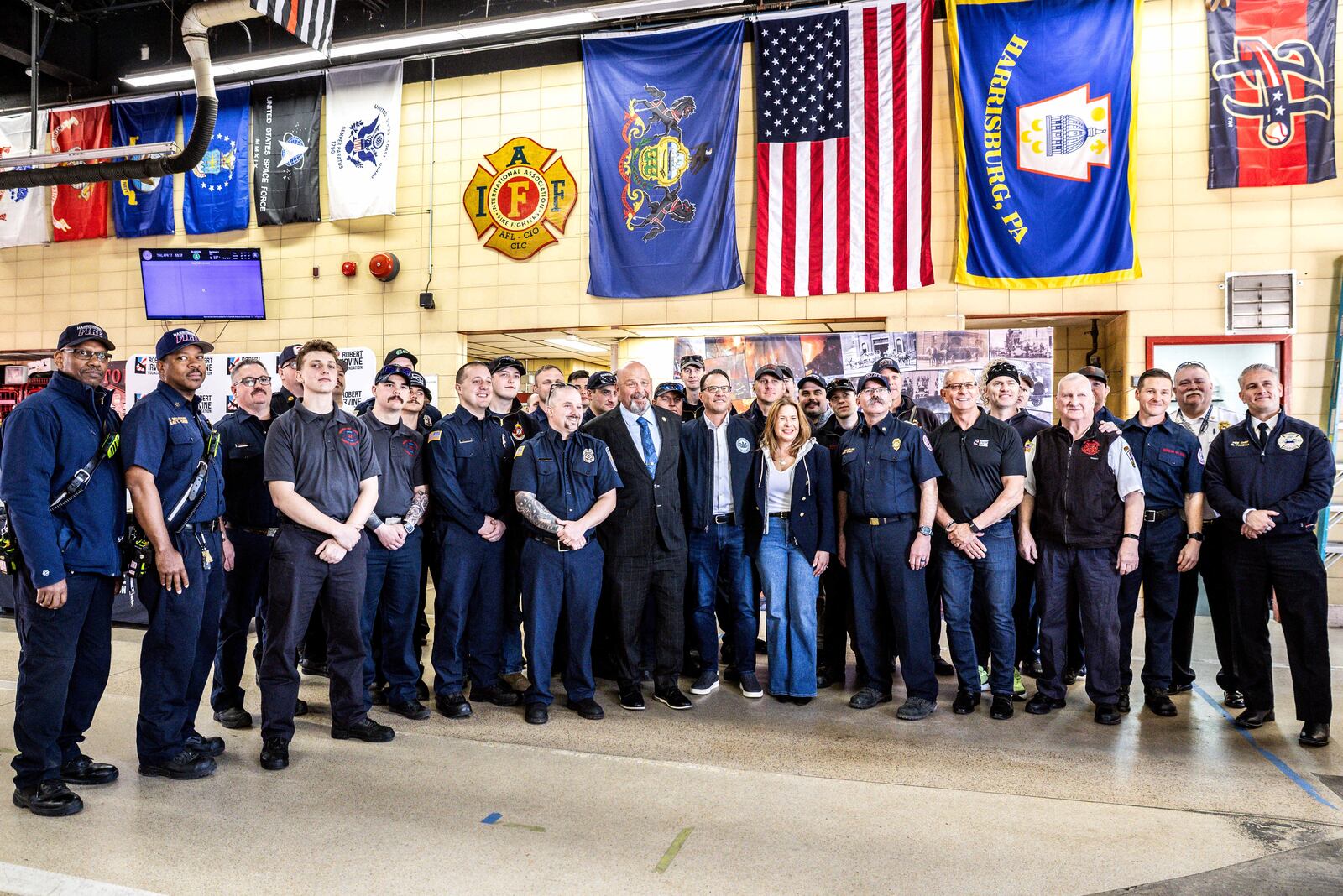 Pennsylvania Gov. Josh Shapiro and first lady Lori Shapiro, in center, pose for a photo with firefighters, Thursday, April 17, 2025, thanking them for their efforts after Sunday's arson attack at the Governor's Residence. (Dan Gleiter/The Patriot-News via AP)