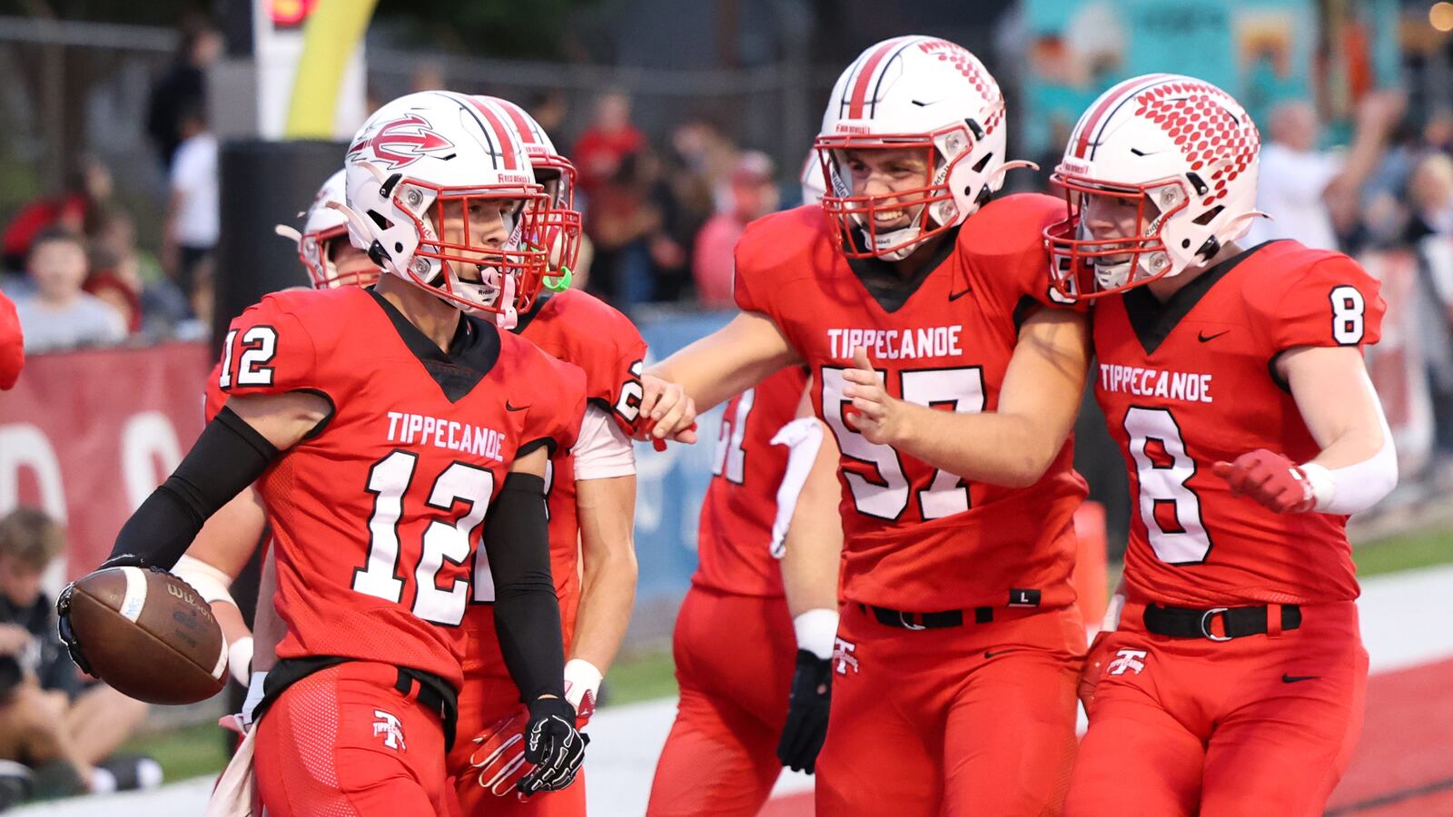 Tippecanoe's Nicholas Wemple (center) and Jackson Robbins (right) celebrate with senior defensive back Max Deckard after Deckard returned an interception for a touchdown in the first quarter of a Miami Valley League game against Sidney on Thursday, Sept. 25 at City Park in Tipp City. The Red Devils forced four turnovers and won 62-0. BRYANT BILLING / STAFF