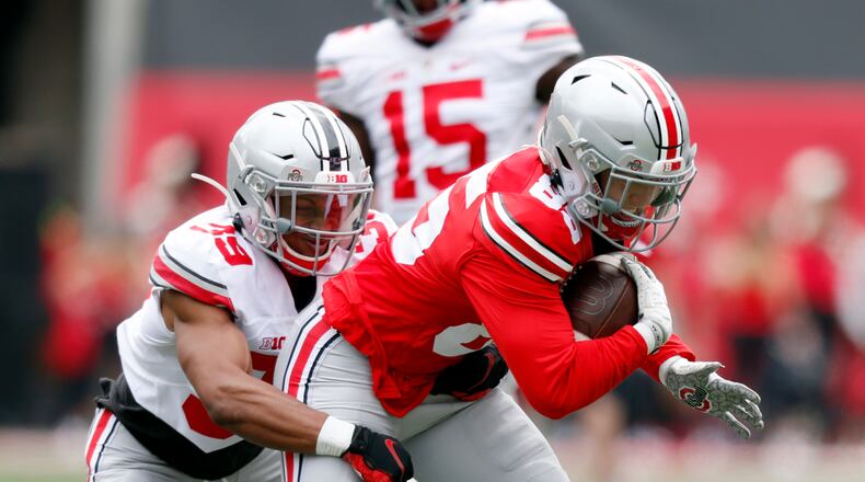 Ohio State wide receiver Austin Kutscher, right, is stopped by defensive back Andrew Moore during the Buckeyes' spring NCAA college football game in Columbus, Ohio, Saturday, April 17, 2021. (AP Photo/Paul Vernon)