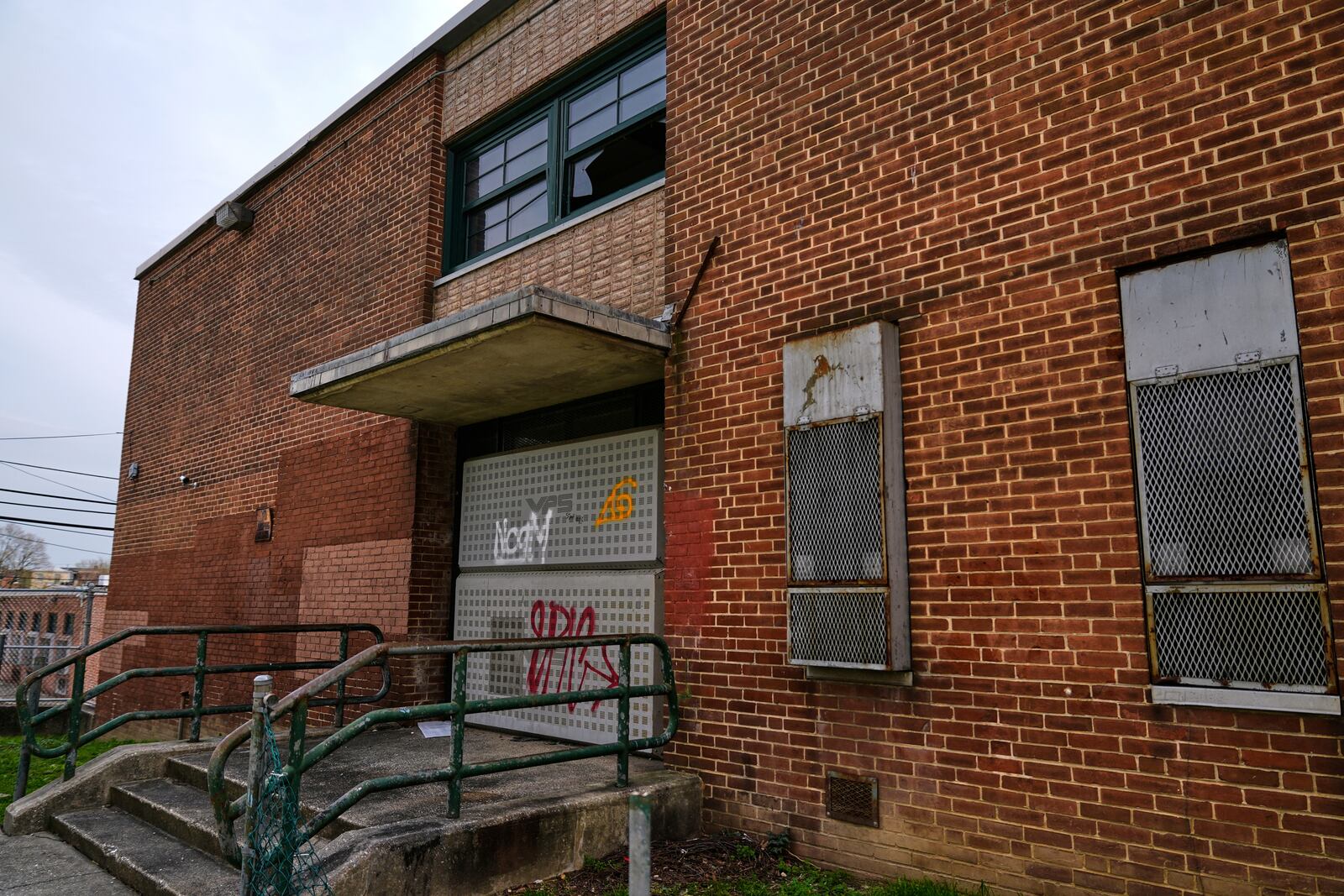 A side entrance of the vacant Lillian S. Jones Recreation Center is boarded shut and a broken window is seen, Monday, April 14, 2025, in the Sandtown-Winchester neighborhood in Baltimore. (AP Photo/Stephanie Scarbrough)
