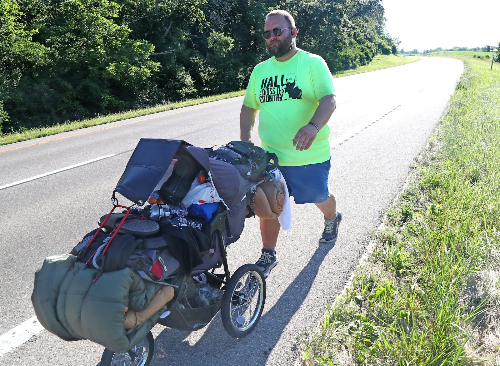 Joe Hall walks along U.S. 40 between South Vienna and Springfield on Thursday, June 23, 2022. Hall is walking across America in a fundraiser for Dayton Children's Behavioral Health Unit. BILL LACKEY/STAFF