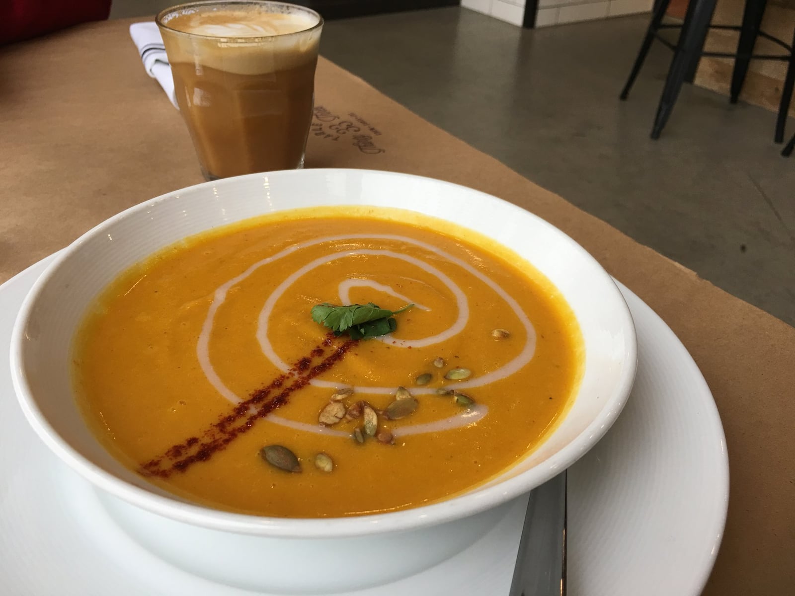 A pumpkin soup ($4 for a cup, $6 for a bowl) from Table 33, made with roasted organic pumpkin, red pepper, coconut milk topped with honey cinnamon coconut cream, cilantro and toasted pumpkin seeds has a refreshing Thai kick to it. The latte in the background was also a nice way to warm up. Contributed photo by Alexis Larsen