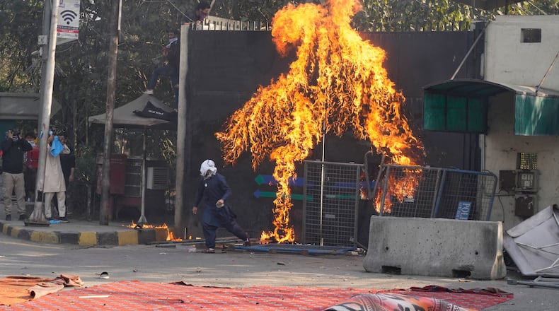 Shiite Muslims set a fire at the U.S. Consulate's entrance gate during a rally to condemn the killing of Iranian Supreme Leader Ayatollah Ali Khamenei, in Lahore, Pakistan, Sunday, March 1, 2026. (AP Photo/K.M. Chaudary)
