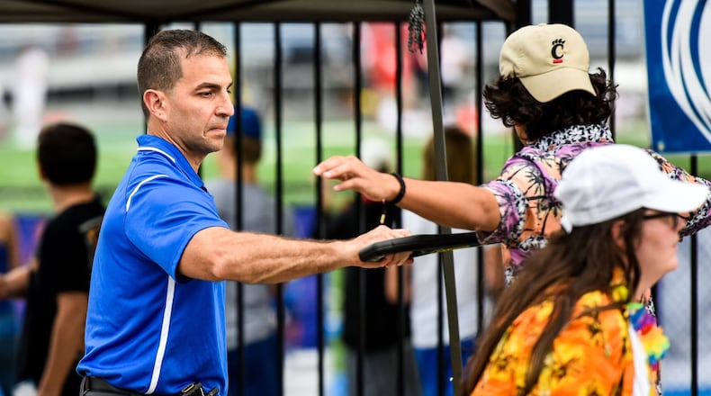 Hamilton High School Principal John Wilhelm uses a metal detector wand to check students at the student entrance before the Sept. 7 football game at Hamilton High School’s Virgil M. Schwarm Stadium. NICK GRAHAM/STAFF