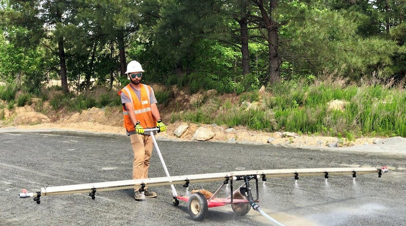 Kenley McAdams, from bioMASON, applies a feeding to the bacteria to harden the surface of the Project Medusa 2,500-square-foot prototype in Durham, N.C. (Courtesy photo/James O’Rourke)