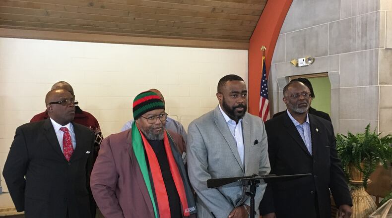 Rev. Rockney Carter, of Zion Baptist Church, speaks at the podium with a group of West Dayton pastors urging a boycott of two forums about the future redevelopment of the Good Samaritan Hospital site. KAITLIN SCHROEDER/STAFF
