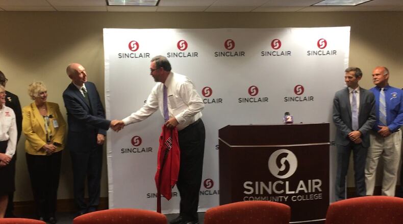 Sinclair Community College President Steve Johnson (center) greets Wright State University Provost Thomas Sudkamp on Monday, as Johnson announces a “talent hub” grant from the Lumina Foundation. Others, from left, are school superintendents Sue Gunnell (Huber Heights), Kevin Bell (Trotwood), Rhonda Corr (Dayton), University of Dayton vice president for strategic enrollment management Jason Reinoehl, and Miamisburg Superintendent David Vail. JEREMY P. KELLEY / STAFF