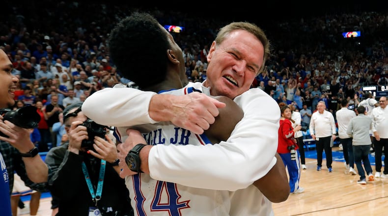 Kansas guard Melvin Council Jr. (14) is hugged by Kansas head coach Bill Self, right, as they celebrate after their team's upset over Arizona in an NCAA college basketball game, Monday, Feb. 9, 2026, in Lawrence, Kan. (AP Photo/Colin E. Braley)