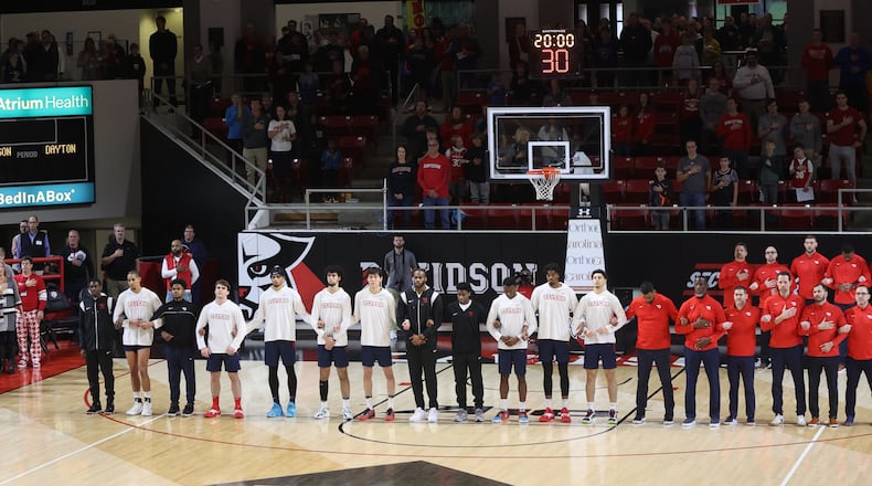 Dayton players and coaches stand for the national anthem before a game against Davidson on Saturday, Dec. 31, 2022, at Belk Arena in Davidson, N.C. David Jablonski/Staff