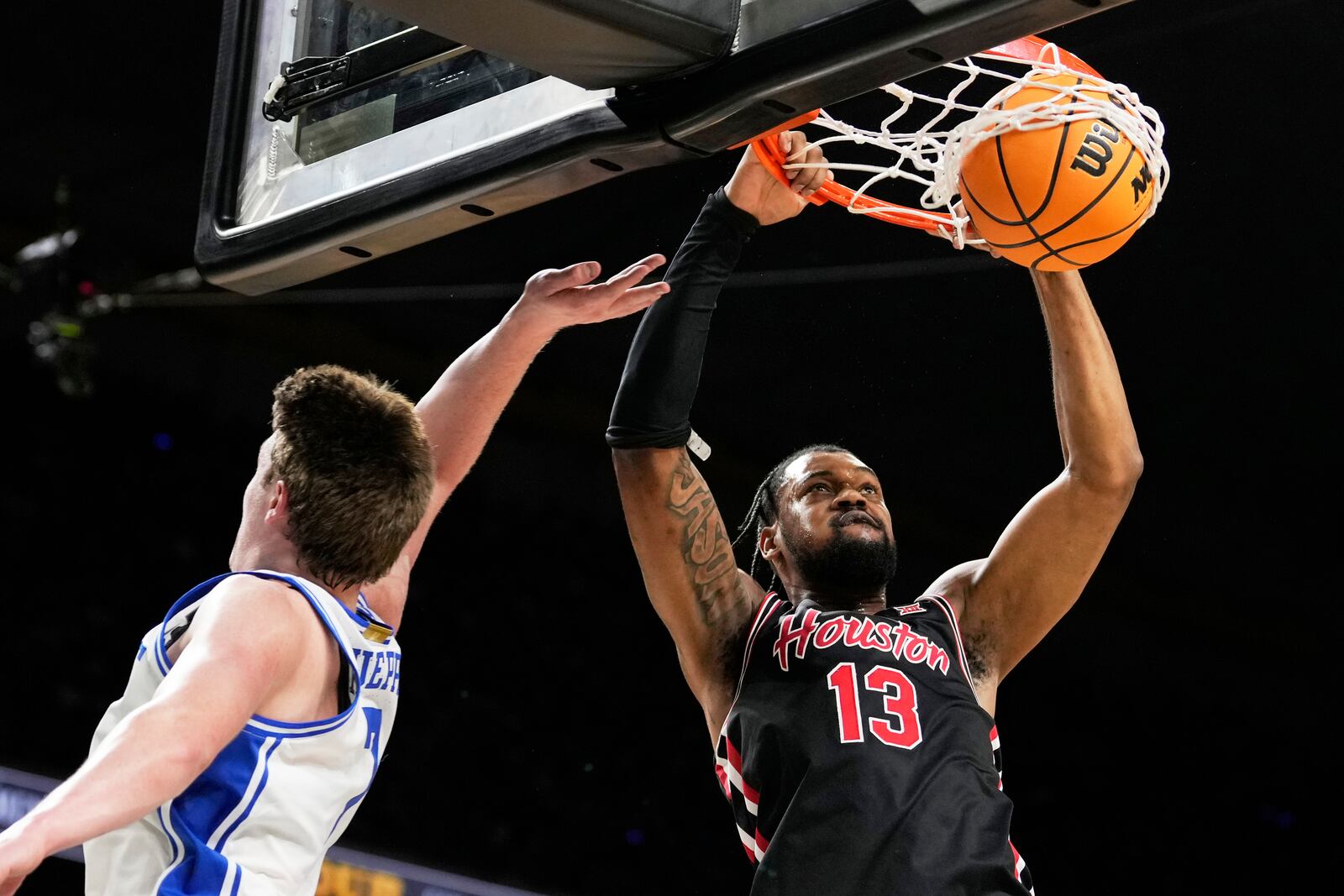 Houston forward J'Wan Roberts dunks past Duke guard Kon Knueppel during the first half in the national semifinals at the Final Four of the NCAA college basketball tournament, Saturday, April 5, 2025, in San Antonio. (AP Photo/Brynn Anderson)