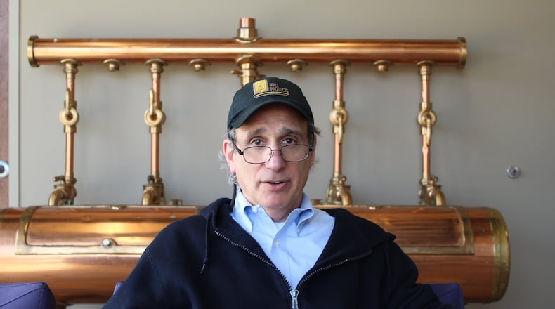 Jim Hochberg, vice president of Malt Products Corp., sits in the lobby of the Dayton facility in front of an old lauter tun that was used to separate wort. CORNELIUS FROLIK / STAFF