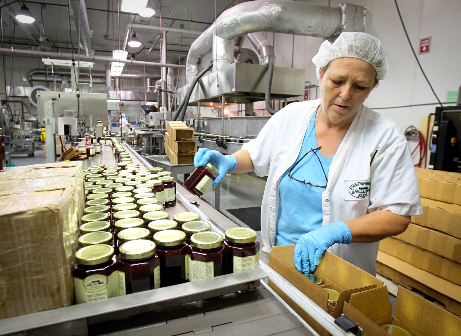 Laurie Ricketts packs jars on the production line Friday. Robert Rothschild Farm in Urbana is purchasing product lines from Tulocay & Co. in California, including their line of marinades, condiments and other items. They will move production of those products to Urbana, creating new jobs although it's not yet clear how many. The company has been working on this for six months and said it would not have been possible without the agreement reached earlier this year with Urbana and the county. JIM WITMER / STAFF