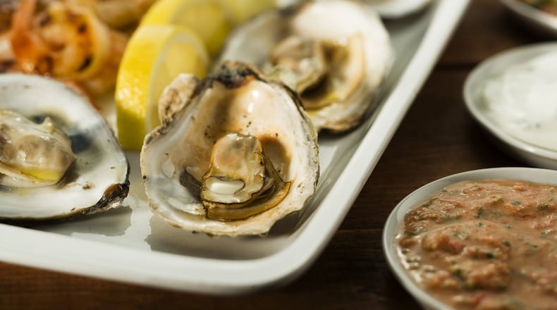 Grilled oysters and shrimp get a kick from a spicy sauce of the Thai chile paste sambal oelek mixed with horseradish, mayo and cilantro. (Bonnie Trafelet/Chicago Tribune/TNS)