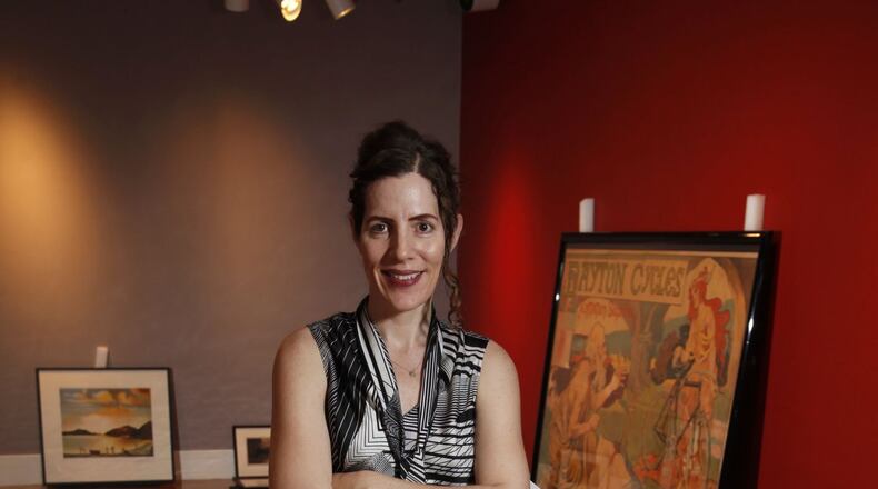 Aimee Marcereau DeGalan, curator of collections and exhibitions at the Dayton Art Institute, is preparing a new exhibit of art depicting sports. The museum’s chief designer Martin Pleiss constructed a scale model of the exhibit seen in the foreground. TY GREENLEES/STAFF