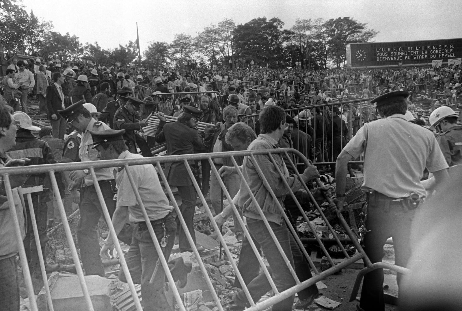 FILE - Belgian policemen and volunteers clear the scene after a disastrous clash between rival soccer fans at the European Cup Final at Heysel Stadium in Brussels, Belgium, on May 29, 1985. (AP Photo, File)