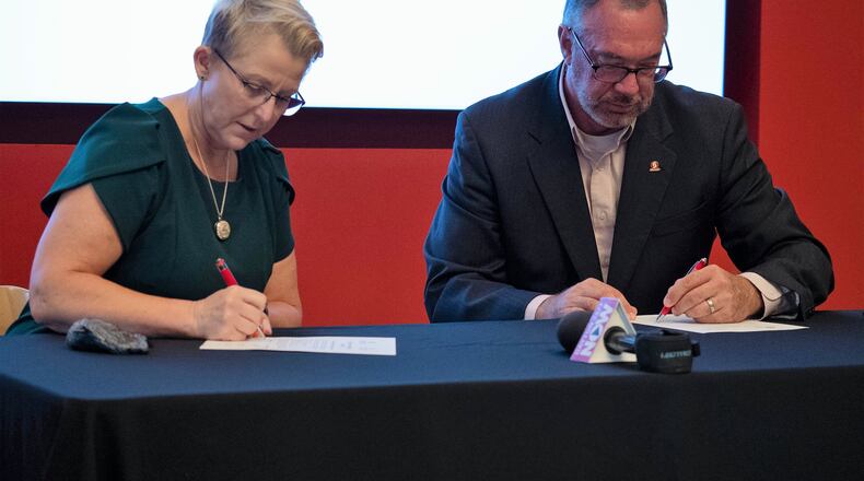 Dr. Sue Edwards, President of Wright State University and Dr. Steve Johnson, President of Sinclair Community College, sign an agreement Thursday to continue the two universities' partnerships. Courtesy of Sinclair Community College.