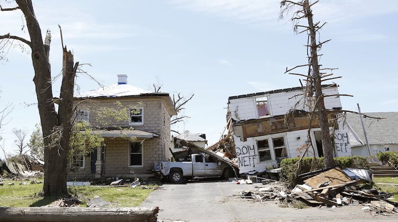 A pickup truck is smashed between two homes on Neff Road in Harrison Twp. Two weeks have passed since a tornado ripped through the area, causing significant damage to homes and businesses. TY GREENLEES / STAFF