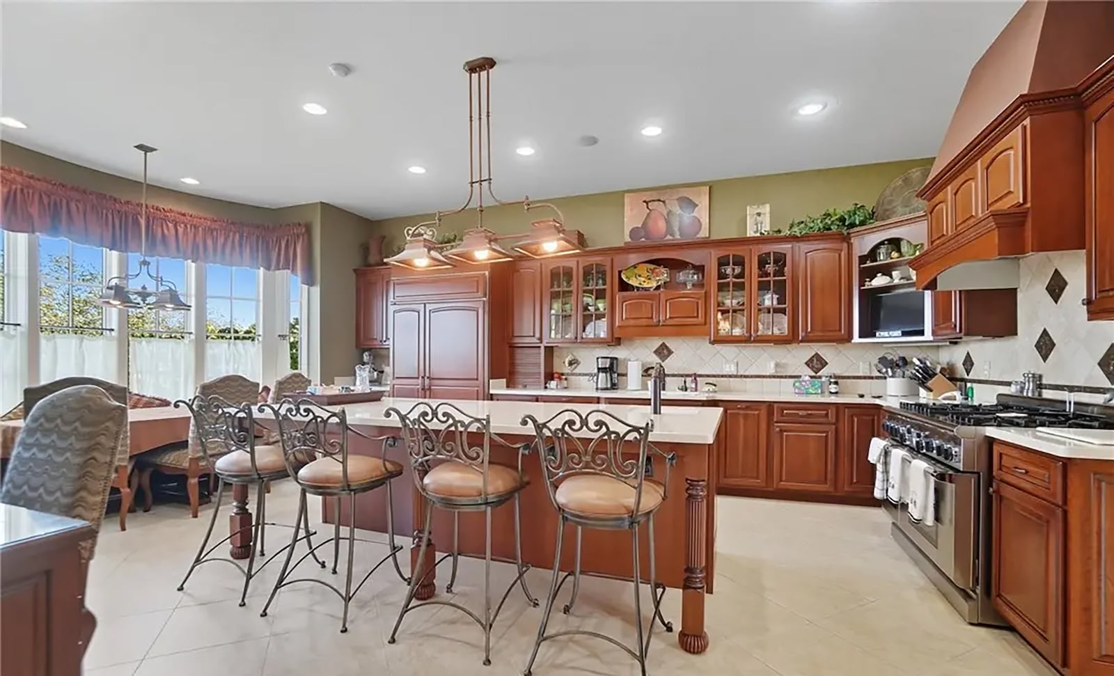 The eat in kitchen has tile flooring, wood cabinets, solid surface countertops and a tile backsplash. It has professional appliances, including a gas range with double ovens. CONTRIBUTED
