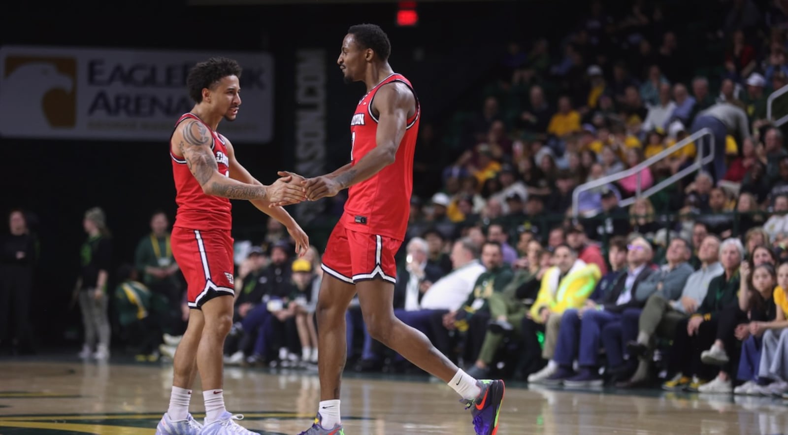 Dayton's Javon Bennett, left, slaps hands with Keonte Jones during a game against George Mason on Wednesday, Feb. 18, 2026, at EagleBank Arena in Fairfax, Va. David Jablonski/Staff