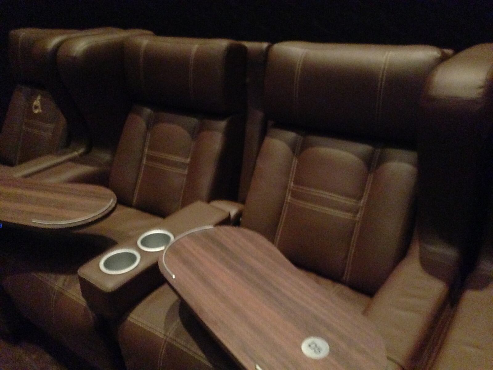 Custom-made leather seats at CineBistro are made for enjoying a meal, and when the seats are reclined, have a wine bottle holder. STAFF FILE PHOTO