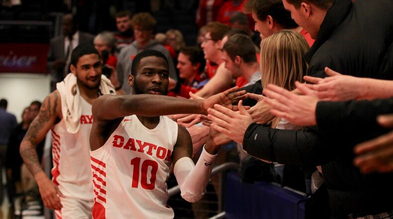 Dayton’s Jalen Crutcher slaps hands with fans after a victory against Drake on Saturday, Dec. 14, 2019, at UD Arena. David Jablonski/Staff