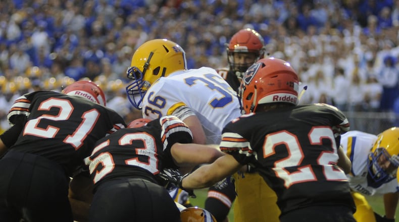 Marion Local running back Alex Partington is met by Coldwater defenders Justin Schwieterman (21), Derek Albers (53) and Ben Wenning (22). Marion Local defeated Coldwater 13-7 in a Week 3 game on Friday, Sept. 8, 2017. MARC PENDLETON / STAFF