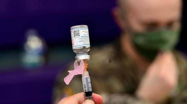 Spc. Brady McNeil, a radiologist with the Vermont Army National Guard, draws up a dose of the Moderna COVID-19 during a vaccination clinic at the Brattleboro Area Middle School, April 14, 2021, in Brattleboro, Vt. (Kristopher Radder/The Brattleboro Reformer via AP, File)