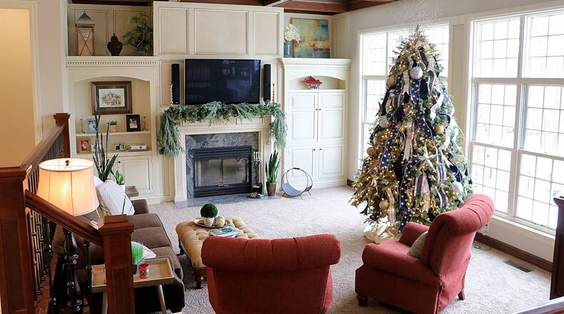 Coffered ceiling and wrought-iron railing accent the sunken great room, which has a wall of windows that looks out over the pool area. Contributed photos by Kathy Tyler
