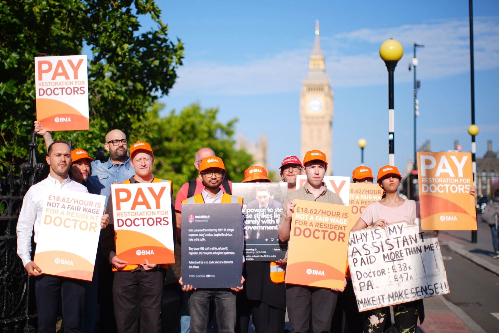 NHS resident doctors hold placards outside St Thomas' Hospital in London, as resident doctors in England, formerly referred to as junior doctors, begin a five-day strike after talks with the government collapsed over pay, Friday, July 25, 2025. ( James Manning/PA via AP)