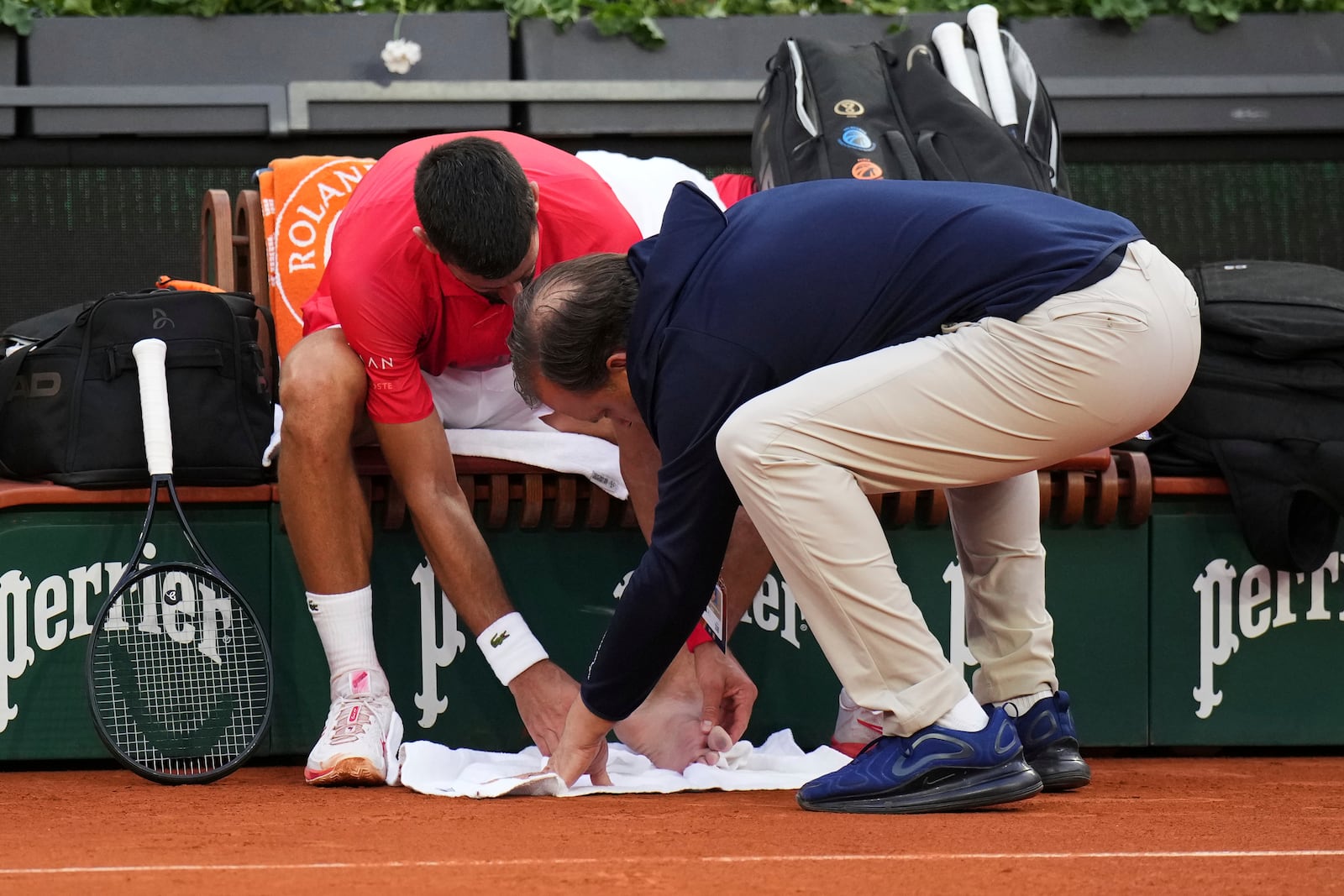 Serbia's Novak Djokovic receives medical assistance during his second round match of the French Tennis Open against France's Corentin Moutet, at the Roland-Garros stadium, in Paris, Thursday, May 29, 2025. (AP Photo/Christophe Ena)