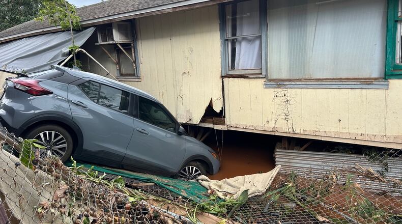 This photo provided by Heather Nakahara shows a car submerged near a flooded home Saturday, March 21, 2026, after flooding in Waialua, Hawaii. (Heather Nakahara via AP)