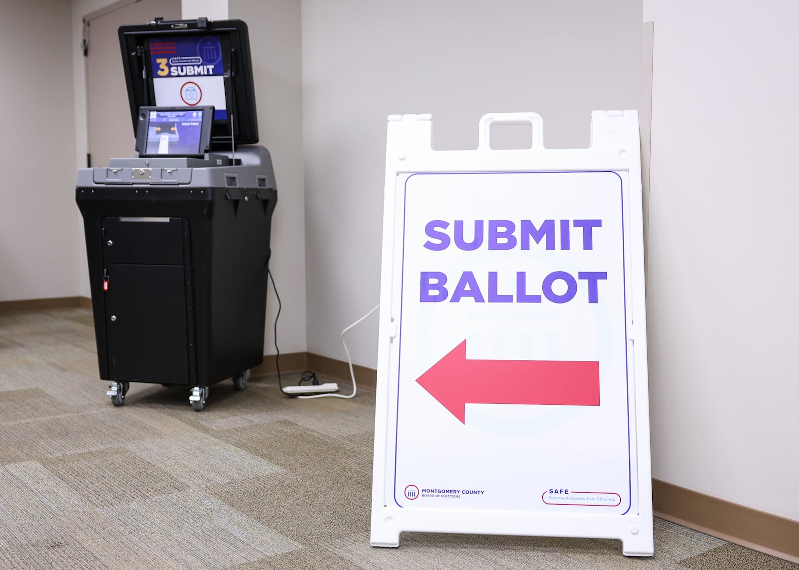 A sign pointing to a ballot scanning machine at Montgomery County Board of Elections on Tuesday, Oct. 7. BRYANT BILLING / STAFF