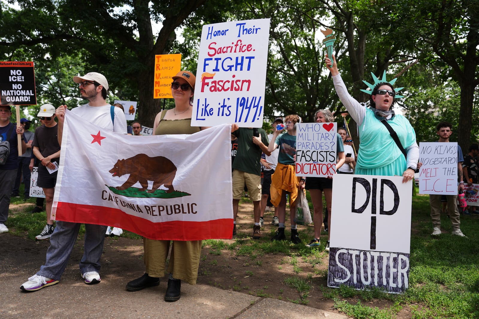 Demonstrators carry signs as they participate in a protest taking place on the day of a military parade commemorating the Army's 250th anniversary, coinciding with President Donald Trump's 79th birthday, Saturday, June 14, 2025, in Washington. (AP Photo/Evan Vucci)