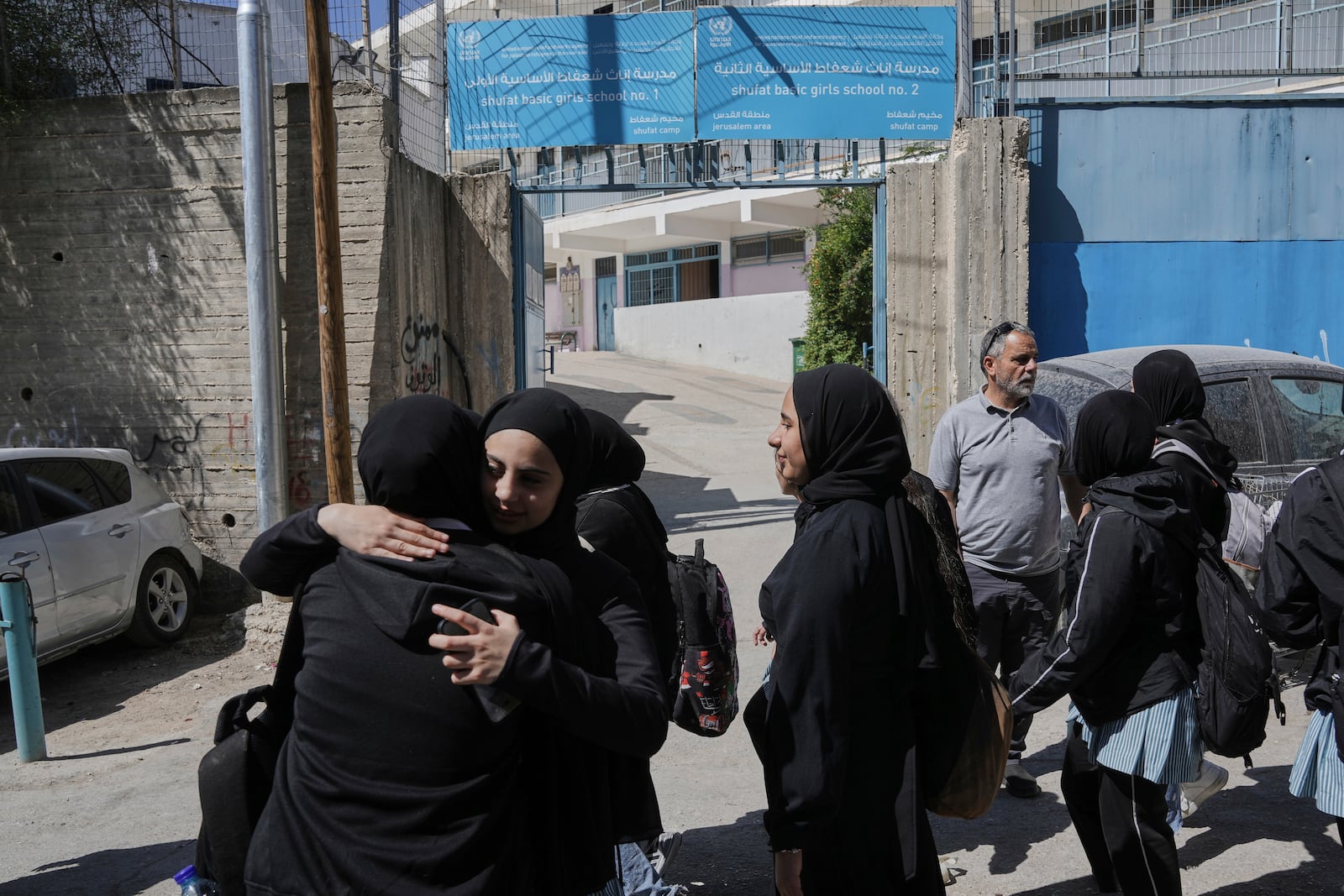 Students stand outside of UNRWA Girls School run by the U.N. agency for Palestinian refugees in the Shuafat Refugee Camp in east Jerusalem, Thursday, May 8, 2025. After Israeli forces ordered the closure of six of its schools in east Jerusalem Thursday. (AP Photo/Mahmoud Illean)
