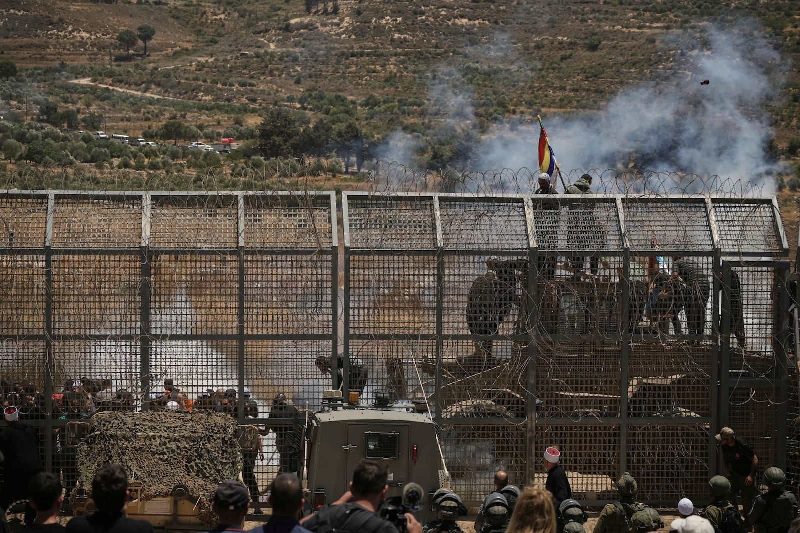Syrian Druze protest near the Israeli-Syrian border, as seen from the town of Majdal Shams in the Israeli-controlled Golan Heights, Wednesday, July 16, 2025, amid the ongoing clashes between Syrian government forces and Druze armed groups in the southern Syrian city of Sweida. (AP Photo/Leo Correa)