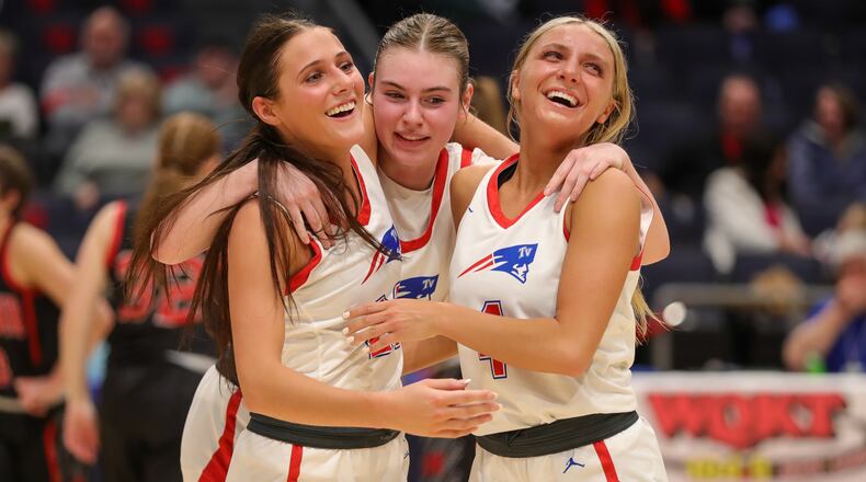 Tri-Village High School seniors Torie Richards (left), Morgan Hunt and Rylee Sagester celebrate as they walk off the floor late in the fourth quarter of their 51-34 victory over Berlin Hiland in a Division IV state semifinal on Thursday night at University of Dayton Arena. CONTRIBUTED PHOTO BY MICHAEL COOPER